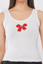 Woman wearing a white cotton ribbed tank top featuring a handcrafted red bow beadwork motif by CherryPop