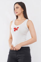 Woman wearing a white cotton ribbed tank top featuring a handcrafted red bow beadwork motif by CherryPop