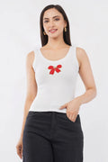 Woman wearing a white cotton ribbed tank top featuring a handcrafted red bow beadwork motif by CherryPop